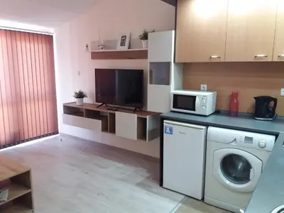 a kitchen with a washing machine and a tv at Апартамент в комплекс Зора 9A in Sozopol