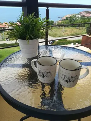 two coffee cups sitting on a glass table at Апартамент в комплекс Зора 9A in Sozopol