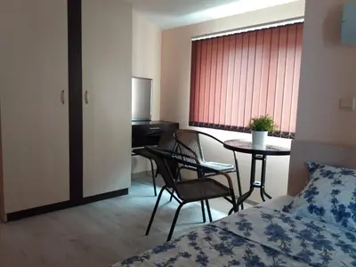 a hotel room with a bed and a table and chairs at Апартамент в комплекс Зора 9A in Sozopol