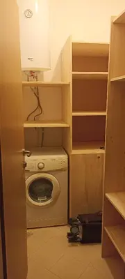 a laundry room with a washing machine and shelves at Cozy apartment with sea view and free parking in Pomorie