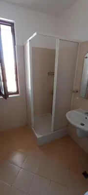 a bathroom with a shower and a toilet and a sink at Cozy apartment with sea view and free parking in Pomorie