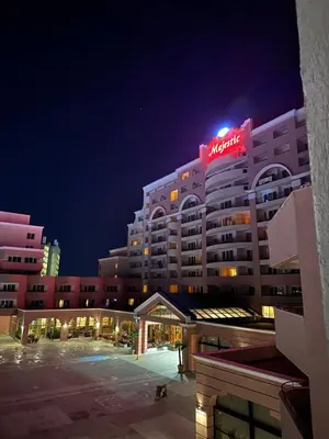 a hotel with a neon sign on top of it at Sunny Majestic Private Apartment in Sunny Beach