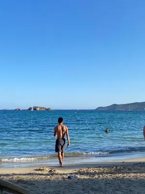 a man walking on the beach near the water at Sunny Majestic Private Apartment in Sunny Beach