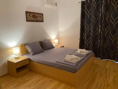 a small bedroom with a bed with two lamps at Harmani Beach Apartment 4 in Sozopol