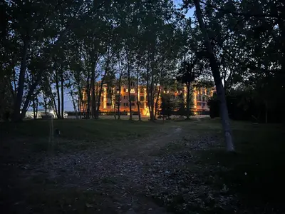 a building is seen through the trees in a park at Aphrodite Park in Sunny Beach