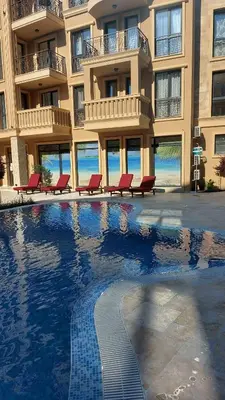 a hotel with a swimming pool in front of a building at Aphrodite Park in Sunny Beach