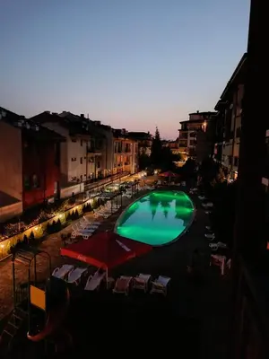 a large green swimming pool in a city at dusk at MitProt Panorama Bay 2 Luks studio 155 in Sveti Vlas