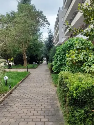 a brick path in a park next to a building at Lovely 3 Room Apartment new furnished Kamelia Sunny Beach in Sunny Beach