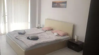 a bedroom with a bed with pink pillows on it at Lovely 3 Room Apartment new furnished Kamelia Sunny Beach in Sunny Beach