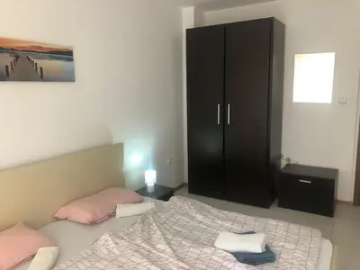 a bedroom with a bed and a black cabinet at Lovely 3 Room Apartment new furnished Kamelia Sunny Beach in Sunny Beach