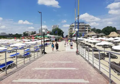 a walkway with chairs and umbrellas on a beach at Billy's two- bed apart for Rent at Sunny Beach in Sunny Beach
