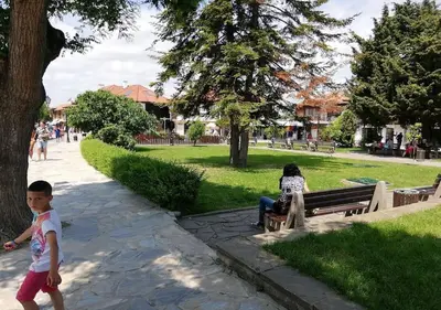 a little boy walking in a park with a woman sitting on a bench at Billy's two- bed apart for Rent at Sunny Beach in Sunny Beach