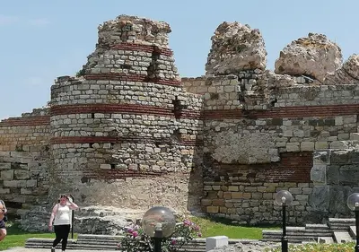 a woman standing in front of a stone wall at Billy's two- bed apart for Rent at Sunny Beach in Sunny Beach