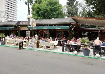 a group of people sitting at tables outside a restaurant at Billy's two- bed apart for Rent at Sunny Beach in Sunny Beach