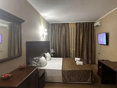 a hotel room with a bed and a television at Studio Festa Pomorie in Pomorie
