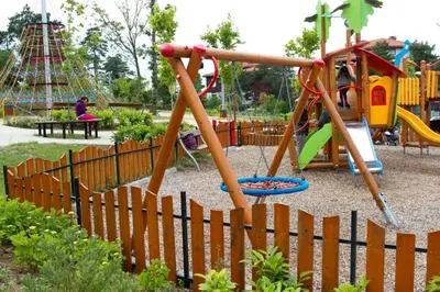 a playground in a park with a wooden fence at 1 bedroom apartment in Santa Marina Sozopol in Sozopol