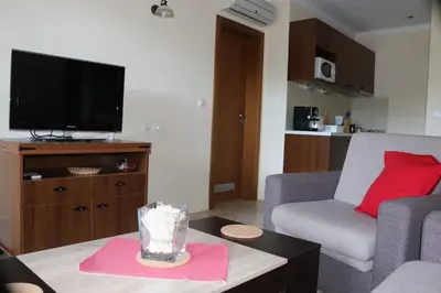 a living room with a couch and a tv at 1 bedroom apartment in Santa Marina Sozopol in Sozopol