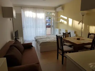 a living room with a couch and a table at Apartament Iglika in Primorsko