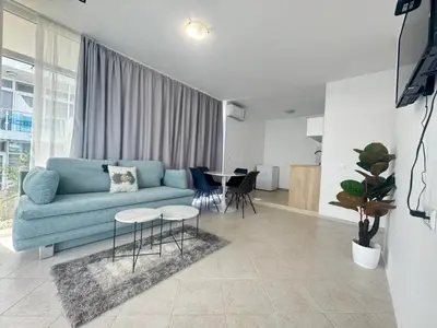 a living room with a blue couch and a table at Villa Mare Blu in Sozopol