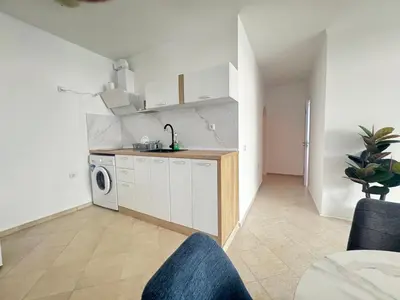 a kitchen with white cabinets and a washer and dryer at Villa Mare Blu in Sozopol