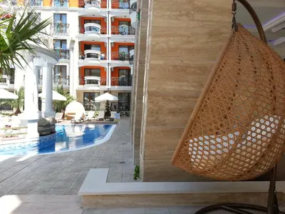 a hanging hammock in a hotel lobby with a building at Harmony Palace - Menada Apatments in Sunny Beach