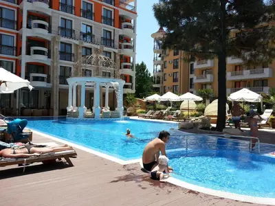 a man playing in a swimming pool at a hotel at Harmony Palace - Menada Apatments in Sunny Beach