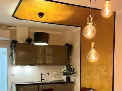 a kitchen with three lights hanging from a ceiling at Golden leaf, swimming pool view in Ravda
