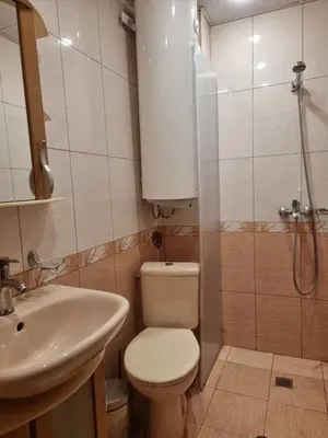 a bathroom with a toilet and a sink and a shower at Апартамент Ломбарди in Varna City