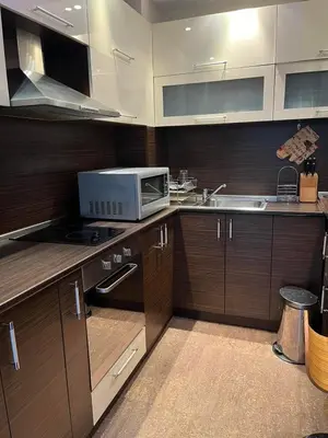 a kitchen with a microwave oven and a sink at Апартамент Ломбарди in Varna City