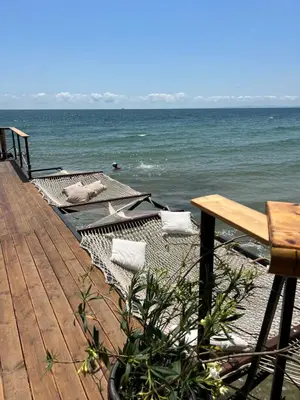 a wooden deck with a bench and the ocean at Sunny apartment in Bellicity complex in Ravda