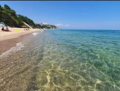 a beach with clear water and people on the beach at Villa Sea House in Byala