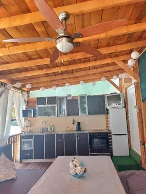 a kitchen with wooden ceilings and a ceiling fan at Каравана Summer time in Chernomorets