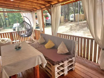 a porch with a table and a chair on a deck at Каравана Summer time in Chernomorets