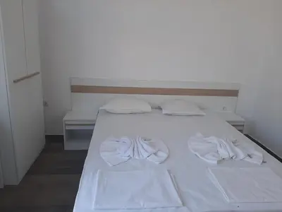 a white bed with two white towels on it at Апартаменти Жени in Tsarevo