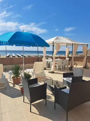 a patio with chairs and umbrellas and the beach at Apartment with sea view in Sunny Beach