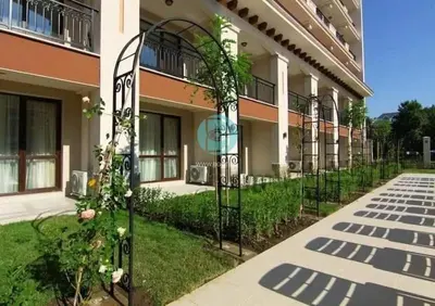 a building with a gate in front of a yard at U Dacha - Premium Apartments in Sunny Beach