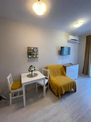 a room with a table and a bed and a table and chairs at U Dacha - Premium Apartments in Sunny Beach