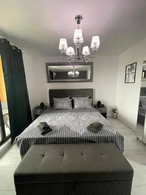 a bedroom with a large bed and a chandelier at Villa Astoria 5. Sveti Vlas k.k. Elenite in Sveti Vlas