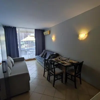 a living room with a table and chairs and a couch at Sunset Beach 3 - Apartments in Sunny Beach