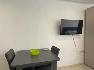a table with a yellow bowl on it and a tv on the wall at PARADISO 'В' 402 Private Apartment Nessebar in Nesebar