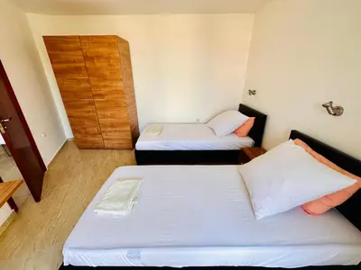 a room with two beds and a wooden door at Cozy Mood Two-bed flat in Sunny Beach in Sunny Beach