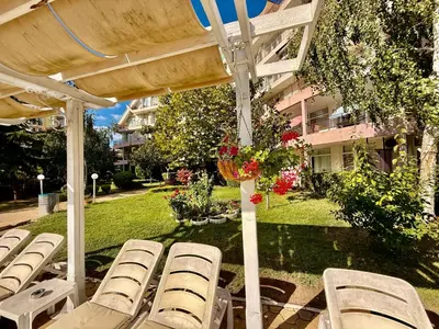 a group of lawn chairs under a pergola at Cozy Mood Two-bed flat in Sunny Beach in Sunny Beach