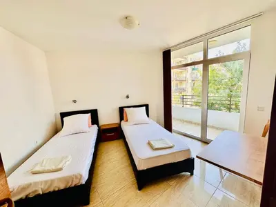 two beds in a room with a window at Cozy Mood Two-bed flat in Sunny Beach in Sunny Beach