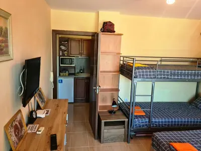 a small room with two bunk beds and a desk at апартамент под наем на първа линия море in Sozopol