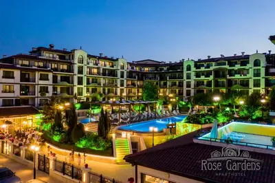 a view of a hotel with a pool at night at Rose Gardens Apart Hotel in Pomorie