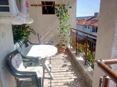 a balcony with a white table and chairs on a building at Farlalievi Guest House in Sozopol