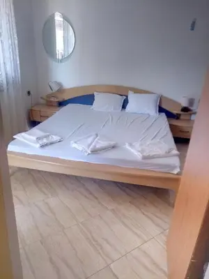a bedroom with a bed with white sheets and pillows at Farlalievi Guest House in Sozopol
