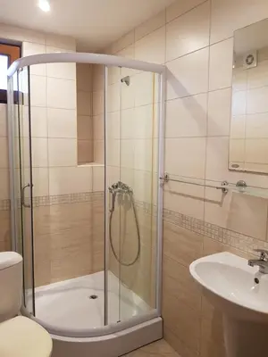 a bathroom with a shower and a toilet and a sink at Villa Nikoli in Nesebar