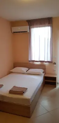 a bedroom with a large bed with a window at Villa Nikoli in Nesebar