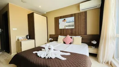 a hotel room with a bed with a flower on it at PARADISO 'В' 609 Studio Nessebar Private in Nesebar